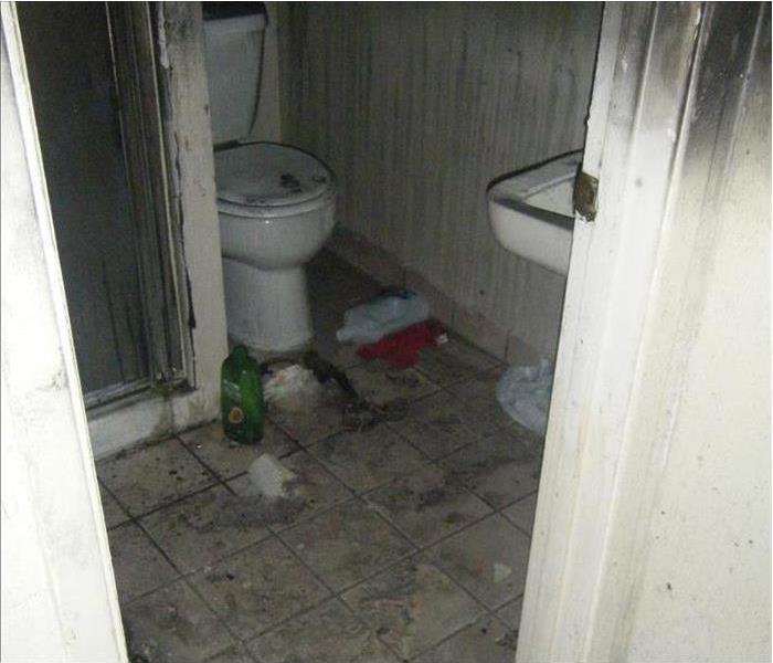 Bathroom with toilet covered in soot and smoke damage