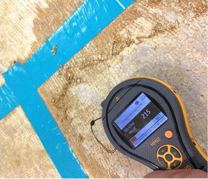 Subfloor with moisture meter taking a reading