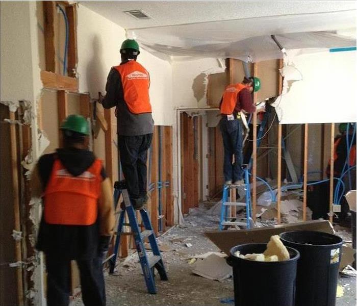 Photo of three SERVPRO technicians in a room working