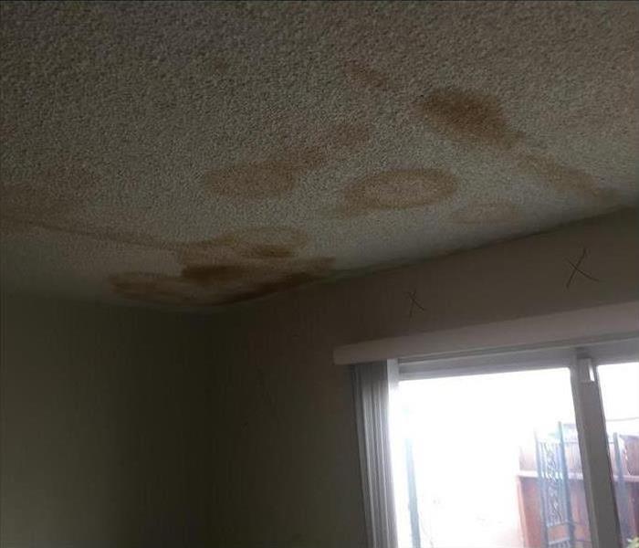 Photo of white popcorn ceiling and brown water spots