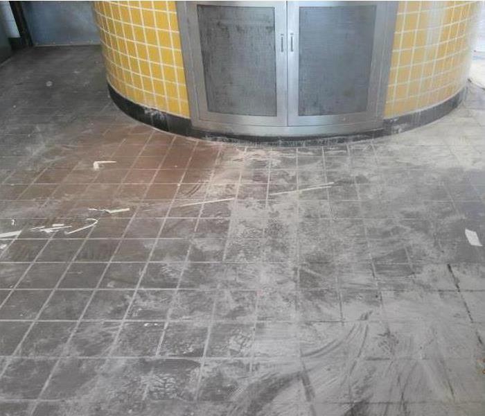 Grey commercial flooring with dirt all over it